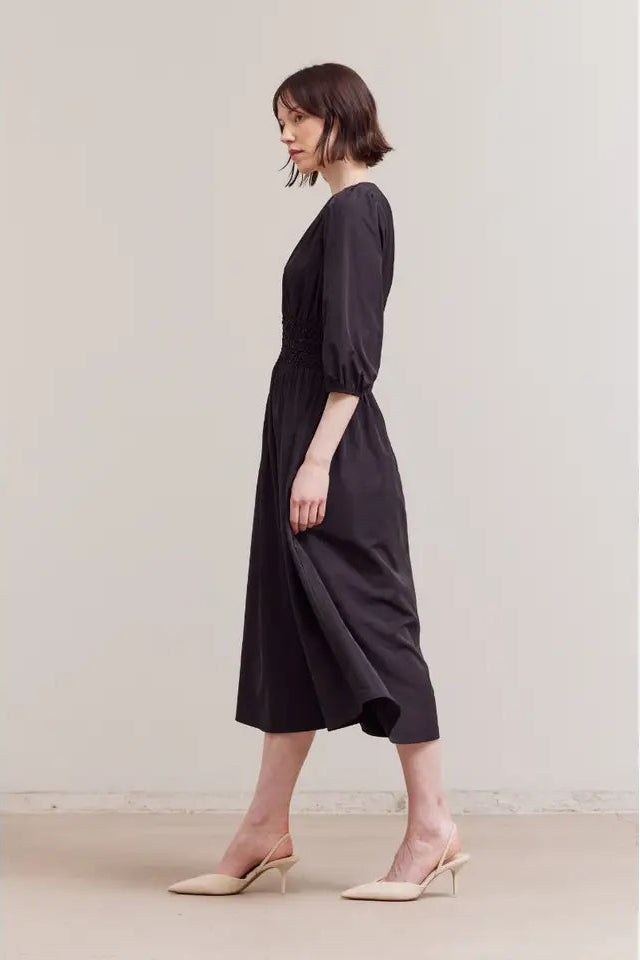 Woman wearing a black dress with a plain background