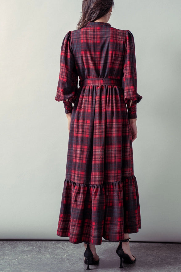 Woman wearing a red plaid maxi dress against a plain background.