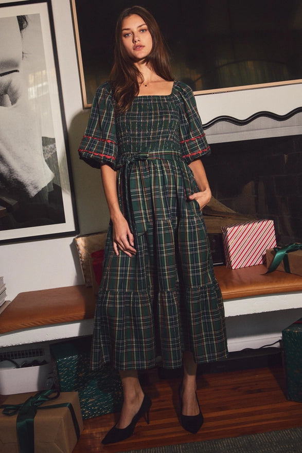 Woman wearing a green plaid midi dress with puff sleeves