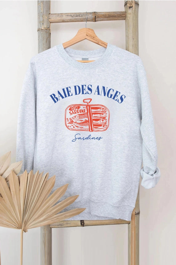 Gray sweatshirt with 'Baie Des Anges' graphic on a wooden hanger against a light background