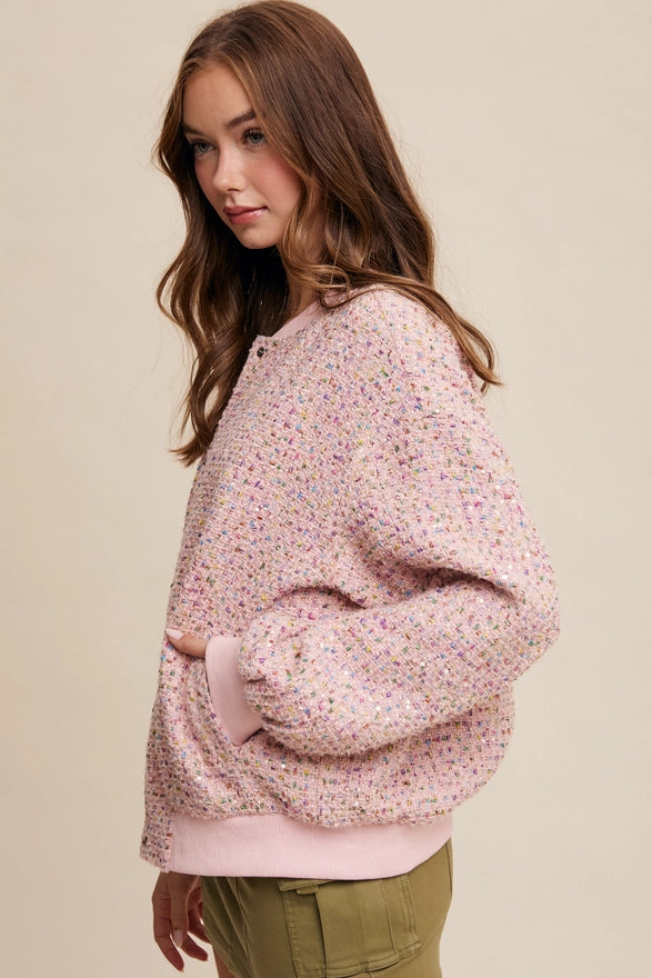 Woman wearing a pink floral sweatshirt against a beige background