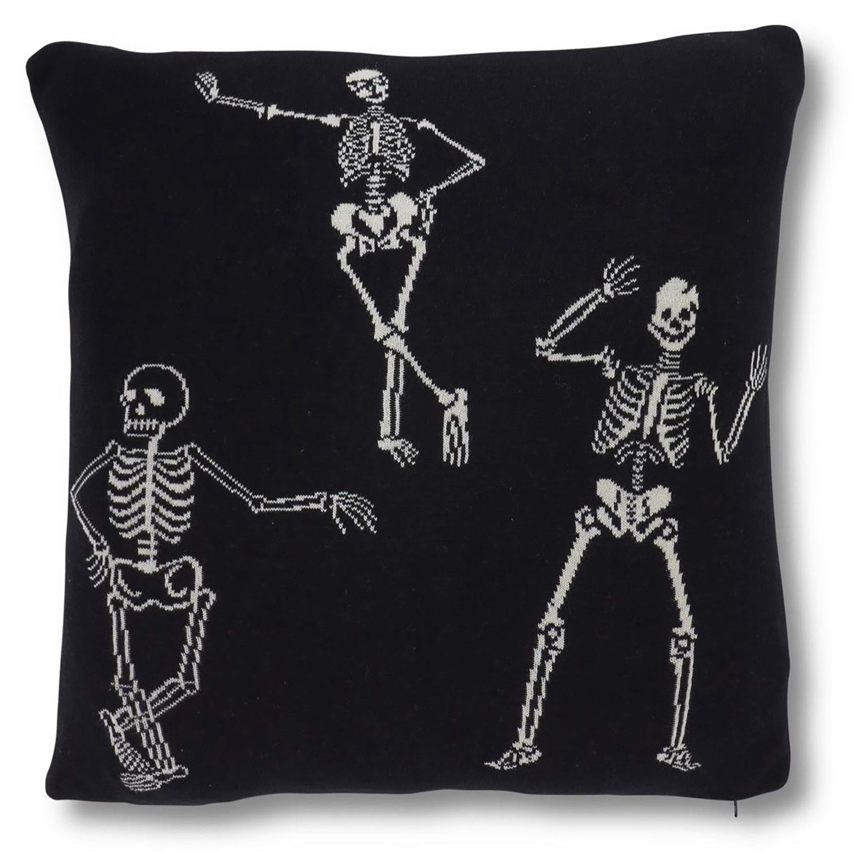 Black pillow with white skeleton designs on a white background