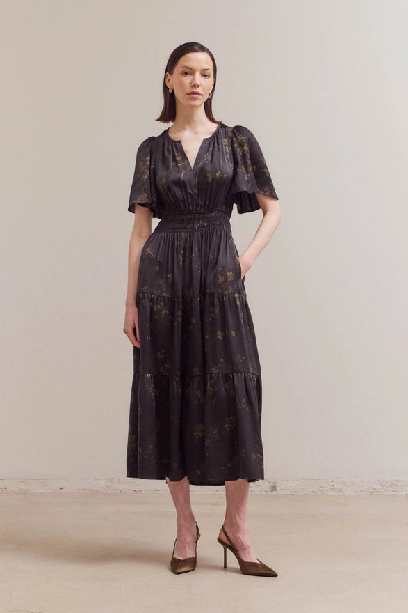 Woman wearing a black lace dress against a plain background
