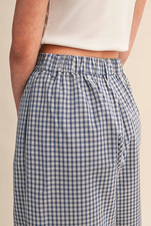 Blue and white checkered pants worn by a person on a beige background
