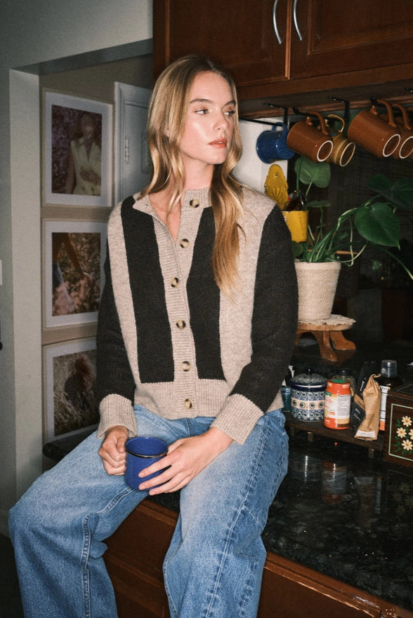 Woman sitting in a kitchen holding a blue mug