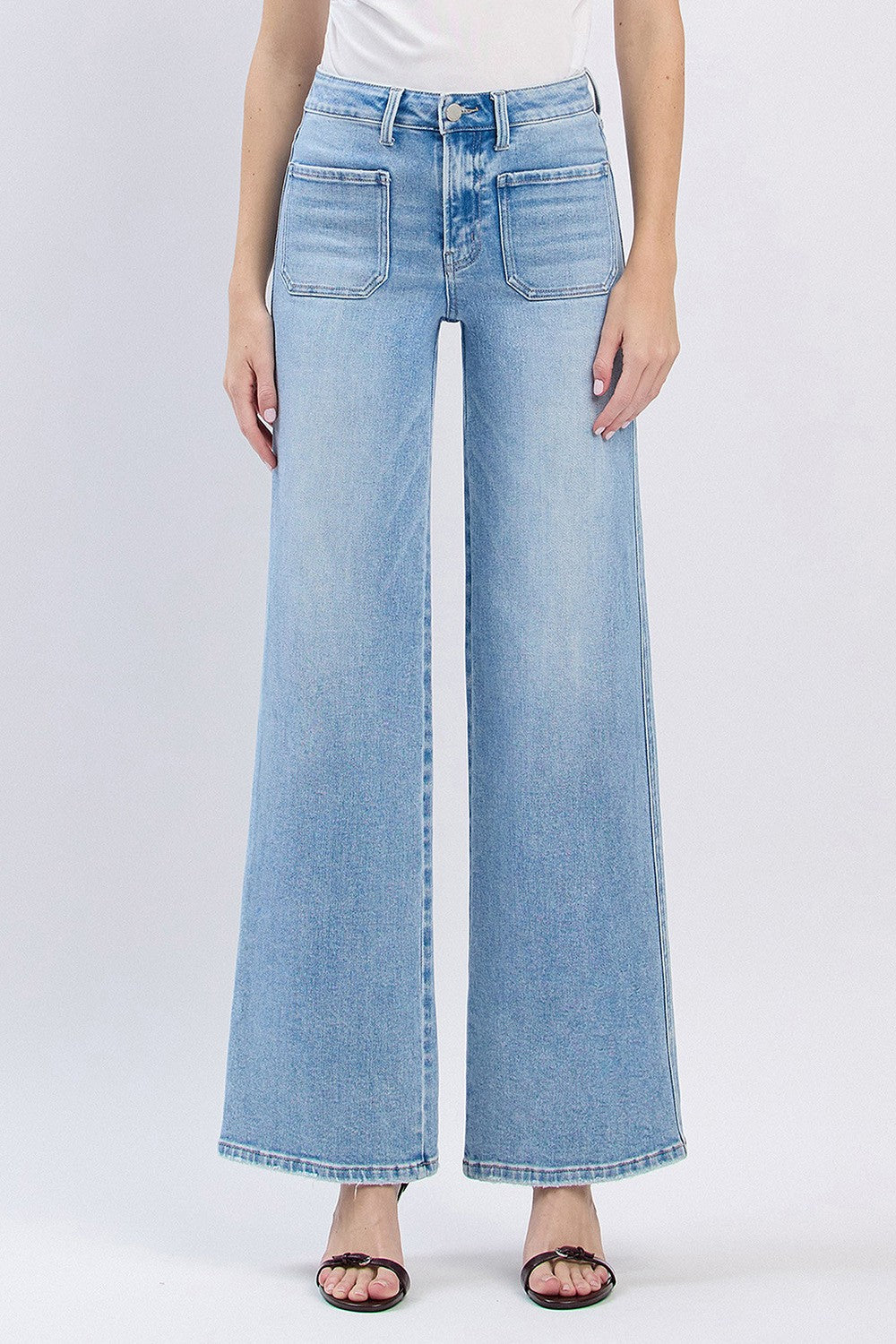 A model wearing high-rise patch pocket wide-leg jeans in a light blue wash denim.
