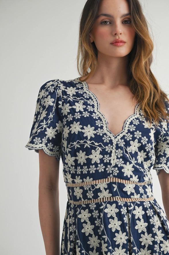 Woman wearing a blue floral dress against a white background