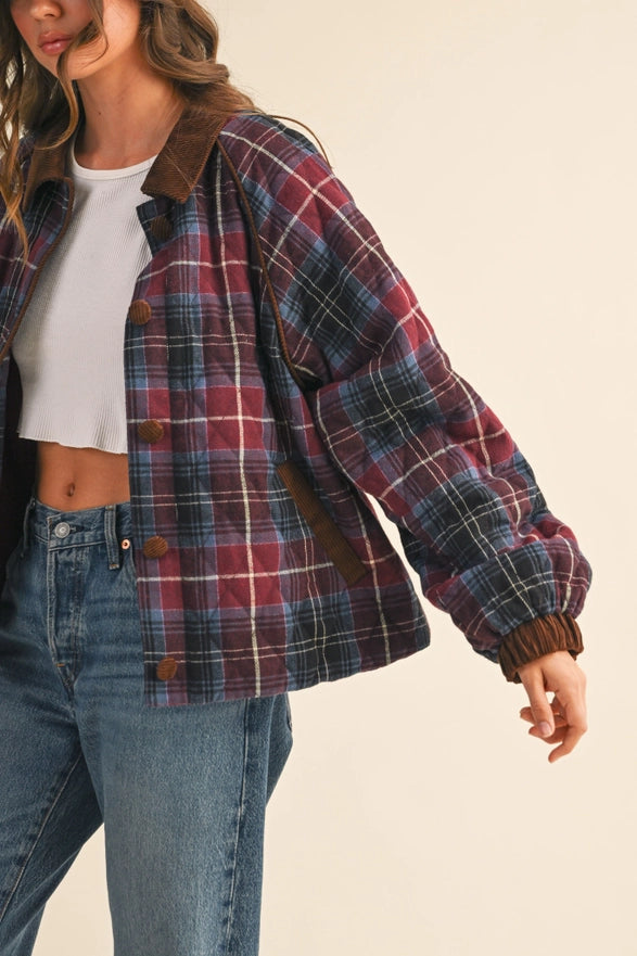 Person wearing a plaid jacket and jeans on a beige background