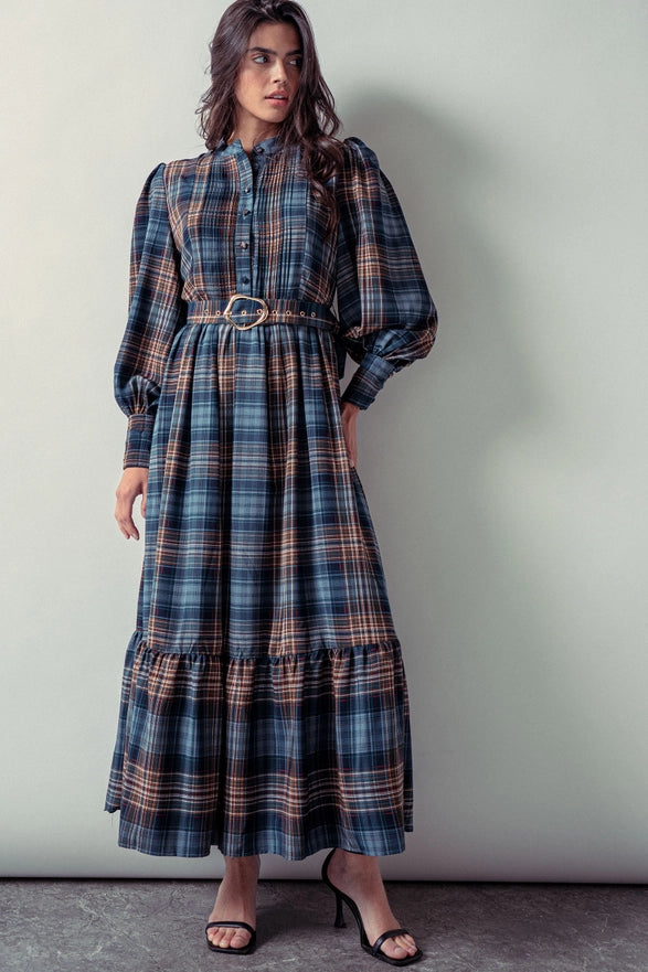 Woman wearing a blue plaid maxi dress against a plain background.