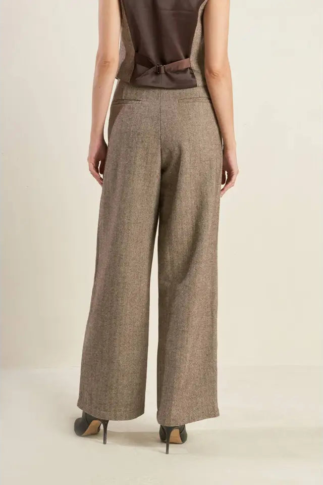 Person wearing brown wide-leg pants on a plain background