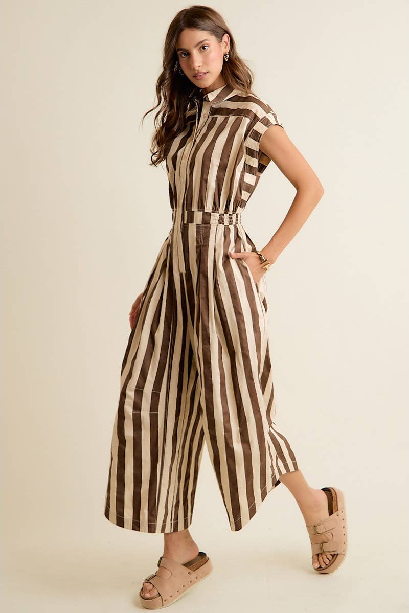 Woman wearing a brown and beige striped jumpsuit on a beige background