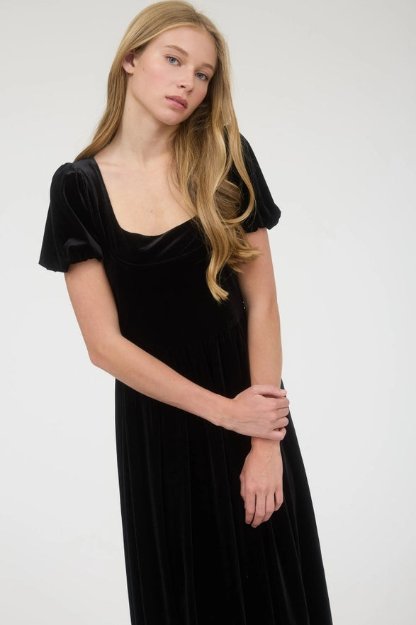 Woman wearing a black velvet dress against a white background