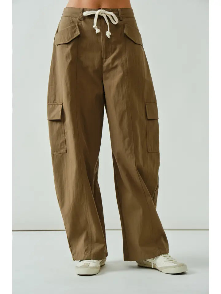 Brown cargo pants worn by a person on a white background
