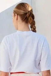 Person wearing a light blue shirt with a plain background