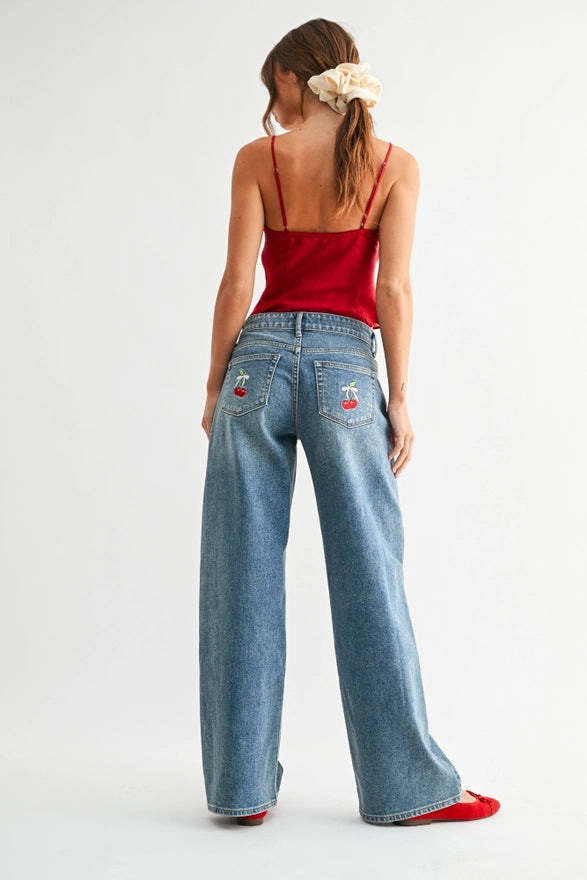 Woman wearing a red top and blue jeans on a white background