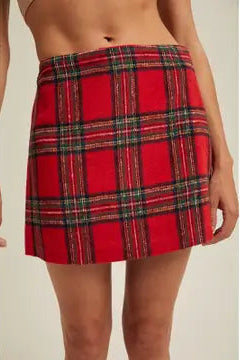 Red plaid skirt worn by a person on a beige background