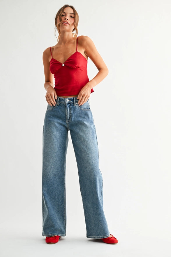 Woman wearing a red top and blue jeans on a white background