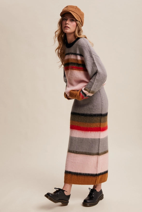 Woman wearing a long, striped sweater dress with a beige background