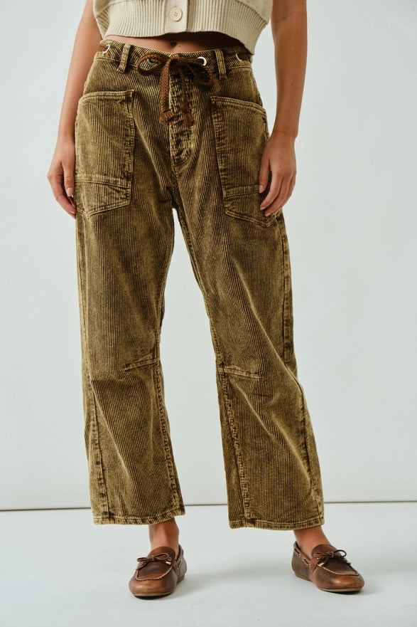 Person wearing brown corduroy pants with a white background