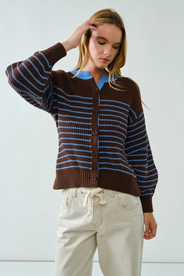 Woman wearing a brown and blue striped cardigan against a white background