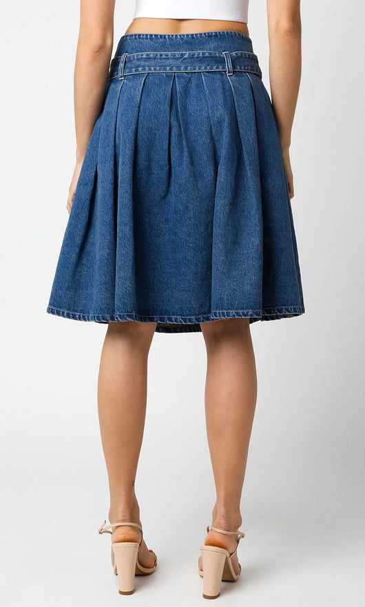 Person wearing a blue denim skirt on a white background