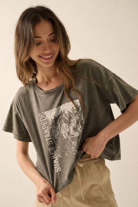 Woman wearing a green t-shirt with graphic design on a beige background