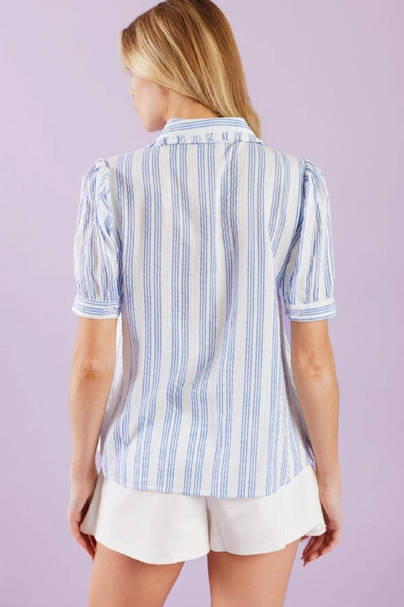 Woman wearing a blue and white striped shirt with a purple background
