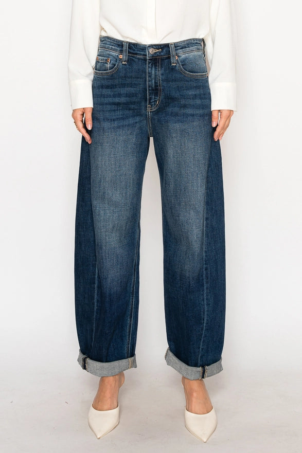 Person wearing blue jeans and white shoes on a white background