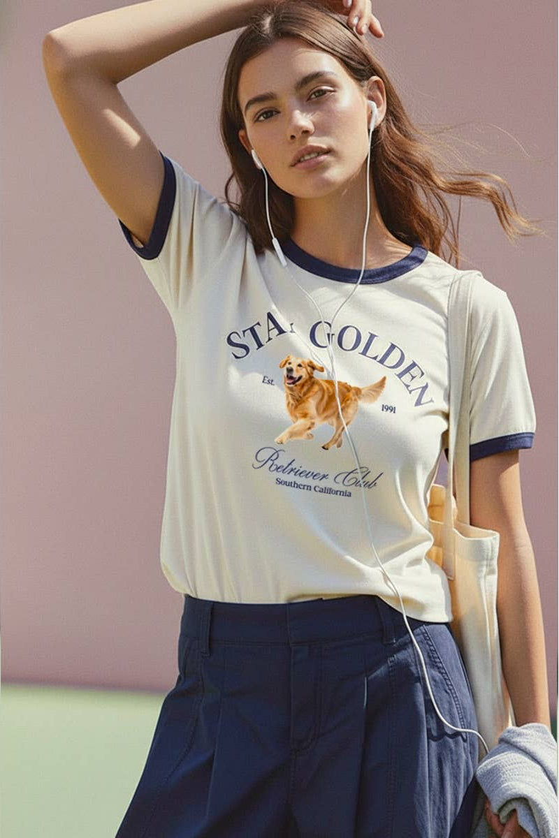 Woman wearing a 'Star Golden Retriever Club' t-shirt with a dog graphic, standing against a light pink background.
