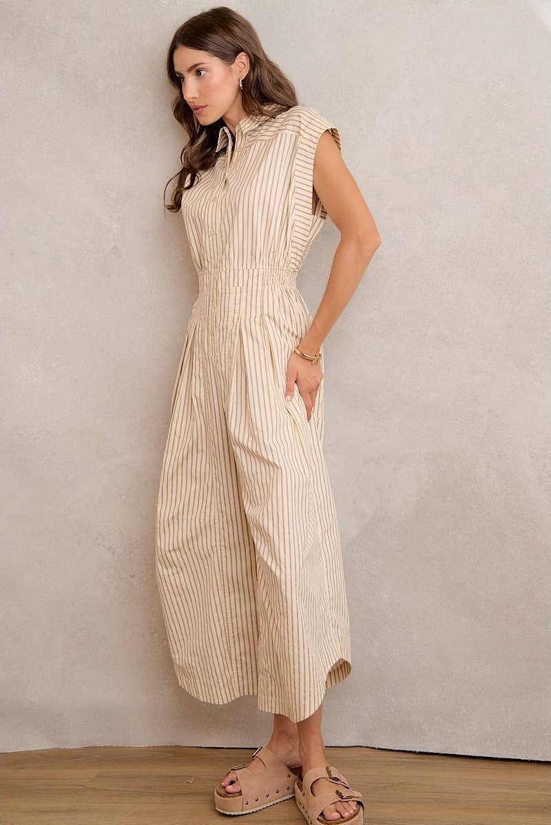 Woman wearing a beige striped dress against a plain background