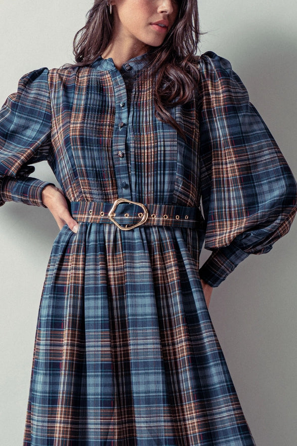 Woman wearing a blue plaid maxi dress against a plain background.