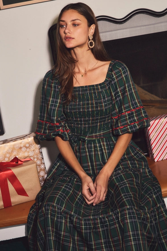 Woman wearing a green plaid midi dress with puff sleeves