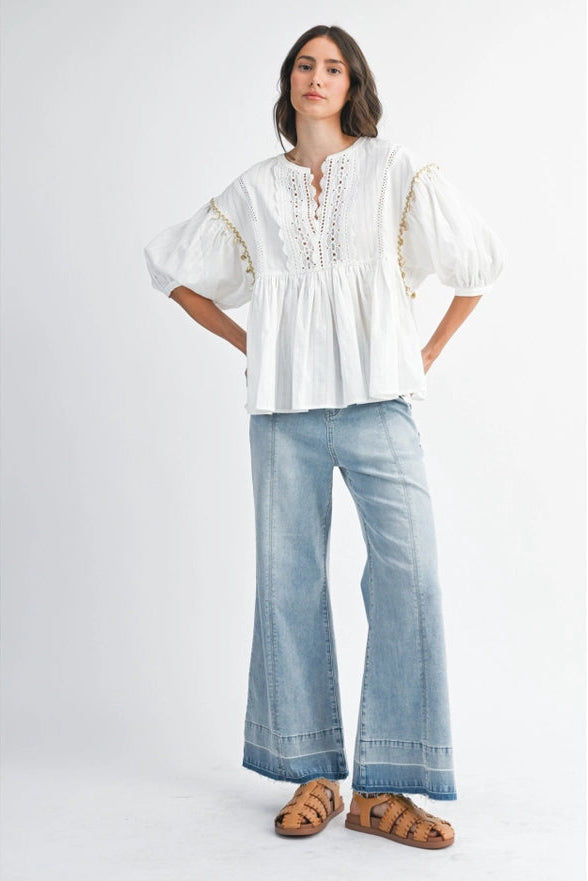 Woman wearing a white blouse and light blue jeans on a white background