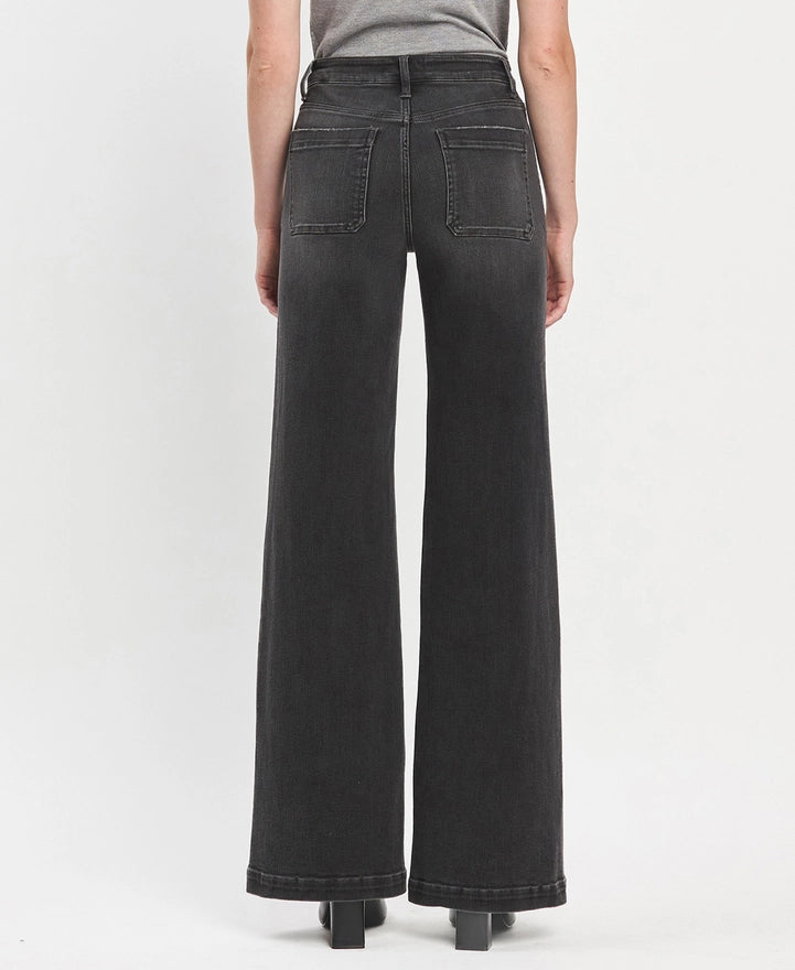 Black wide-leg jeans worn by a person on a white background