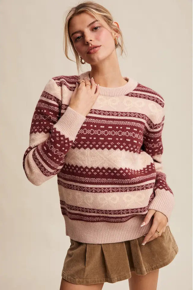 Woman wearing a patterned sweater and skirt against a plain background