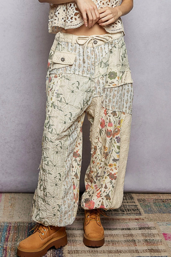 Person wearing floral patterned pants with a plain background