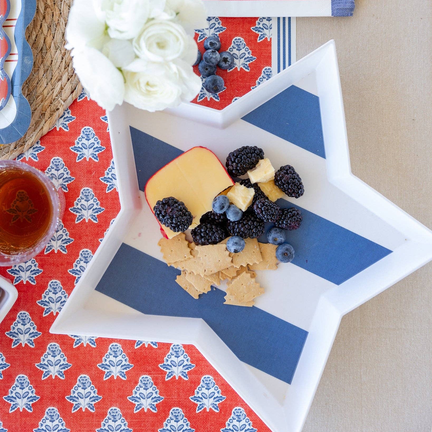 Star-shaped plate with fruit and cheese on a patterned tablecloth