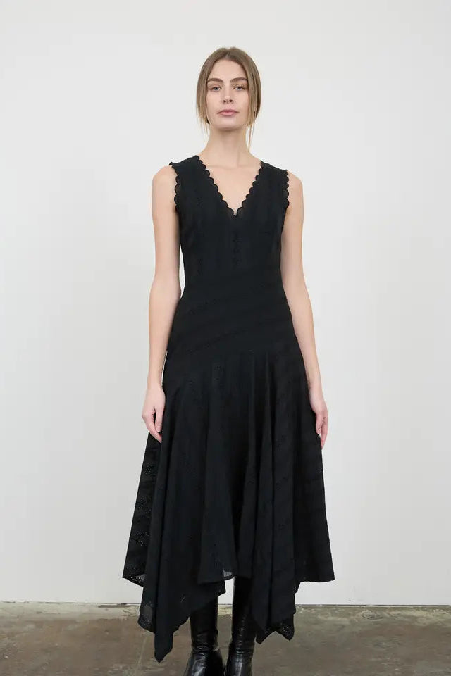 Woman wearing a black sleeveless dress against a plain background