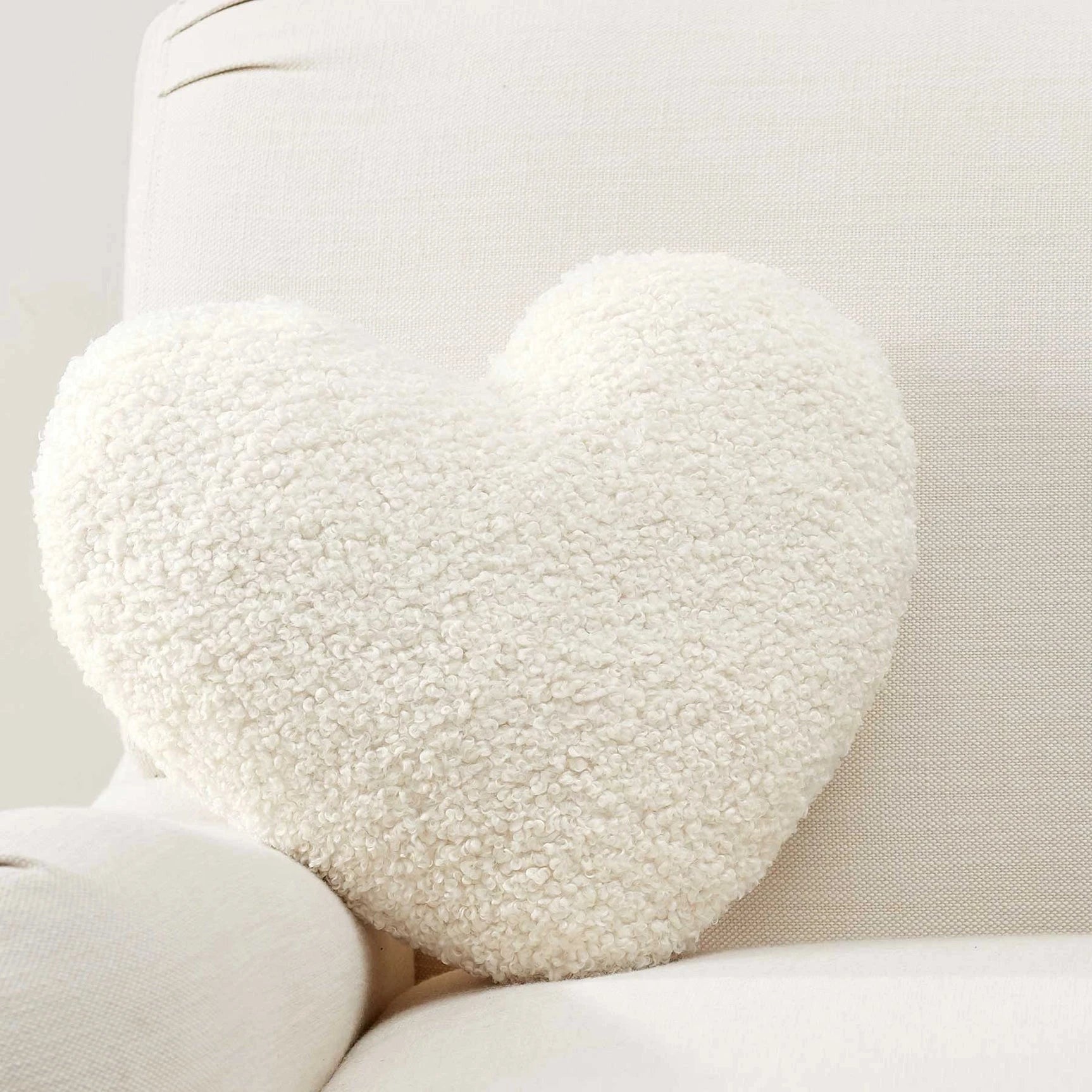 Round white textured pillow on a light-colored sofa