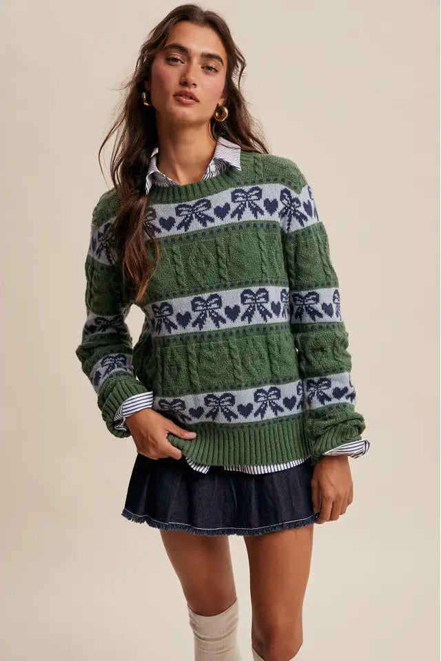 Woman wearing a green sweater with bow pattern and denim skirt on a beige background