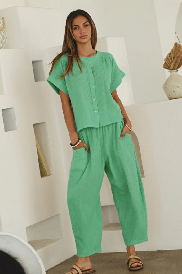 Woman wearing a green outfit in a minimalistic indoor setting