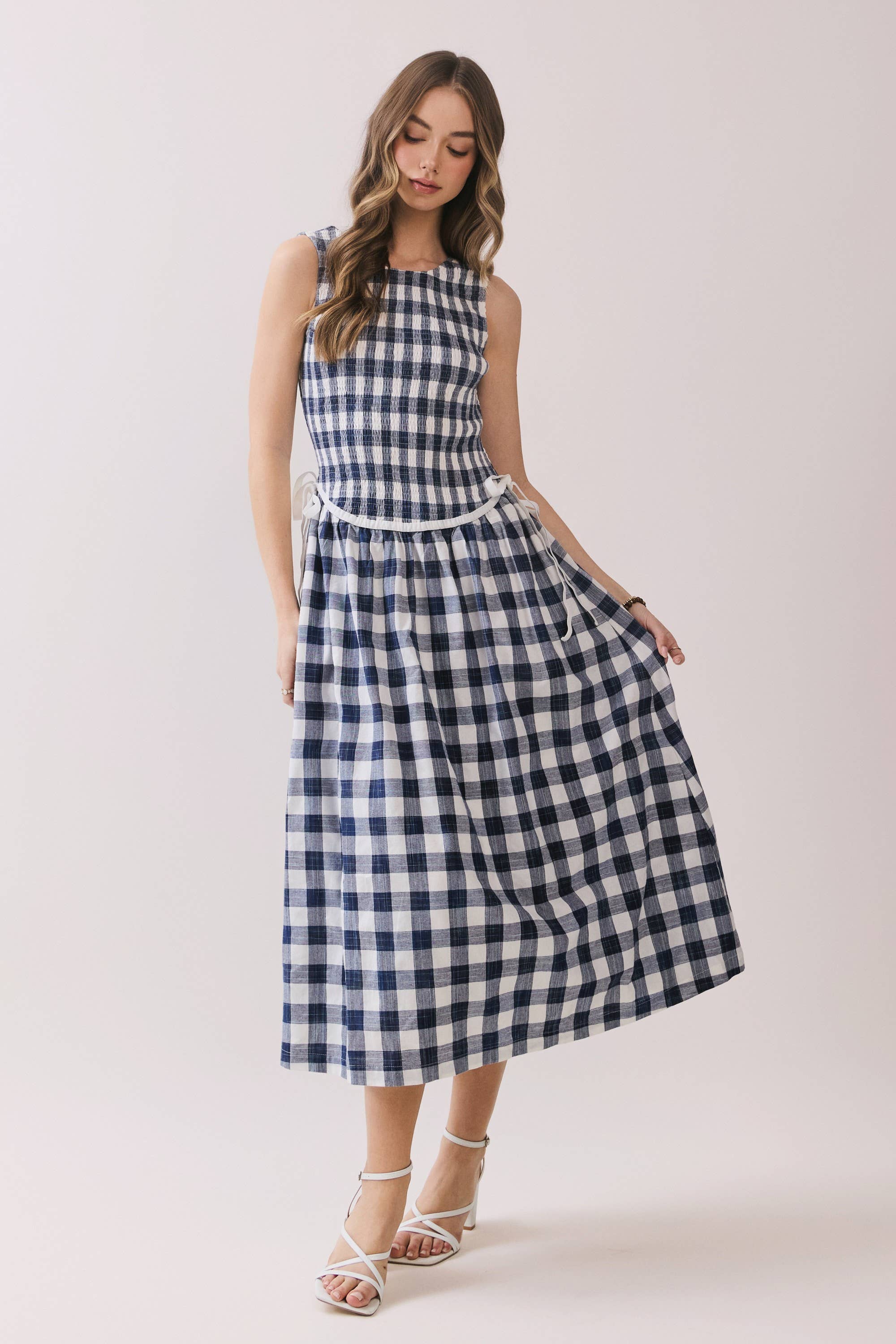 Woman wearing a blue and white checkered dress on a plain background