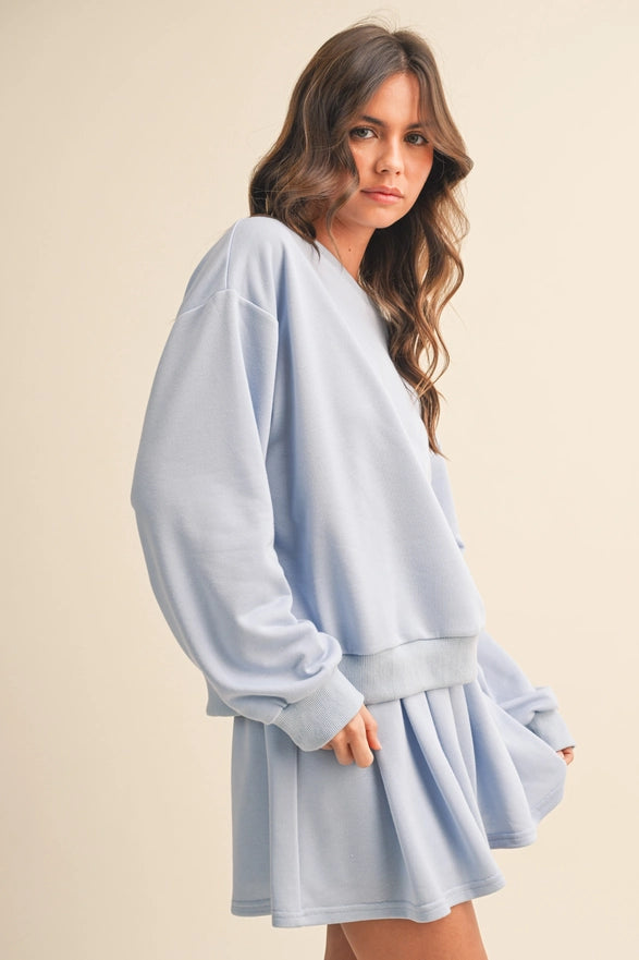 Woman wearing a light blue dress against a beige background