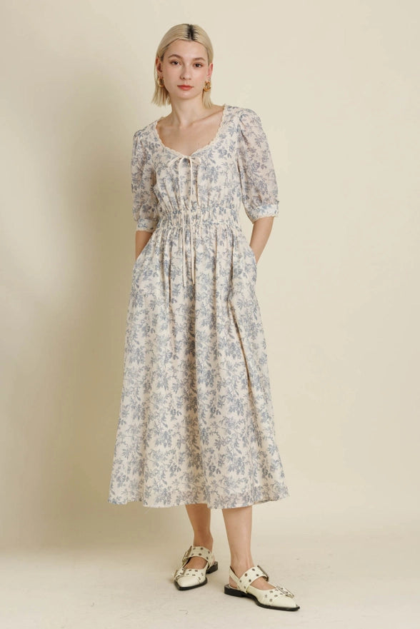 Woman wearing a floral dress against a plain background