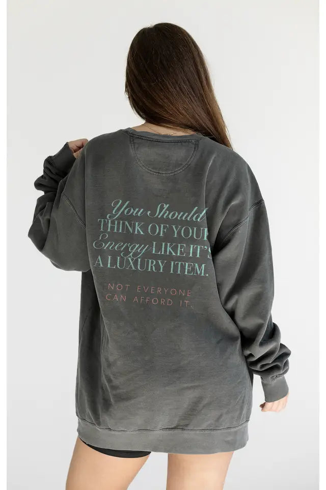 Person wearing a gray sweatshirt with text on the back against a white background