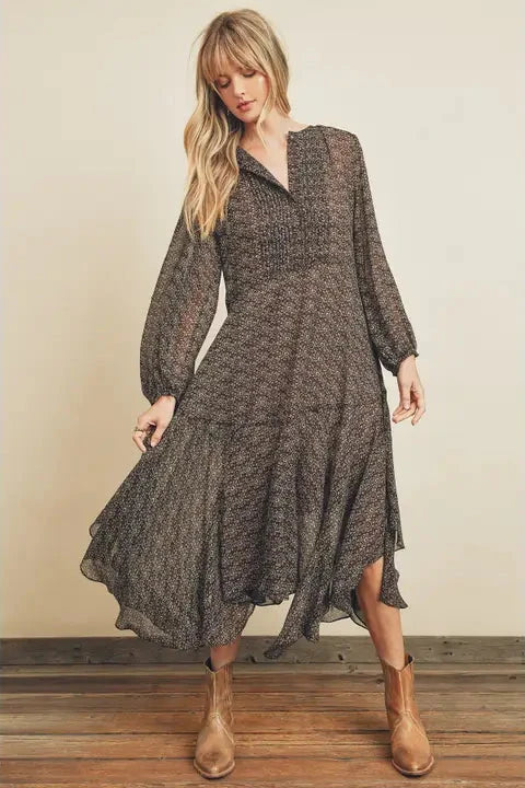 Woman wearing a long, patterned dress with long sleeves against a neutral background