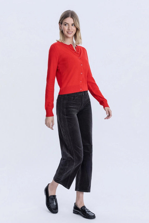 Woman wearing a red shirt and black pants on a white background