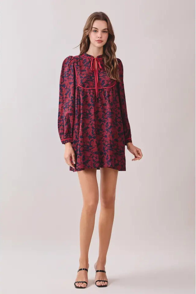 Woman wearing a patterned dress on a plain background