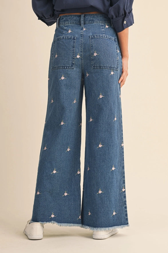 Wide-leg jeans with floral embroidery on a beige background