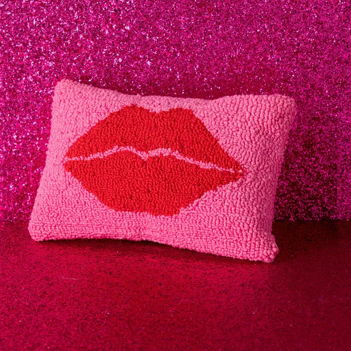 Pink pillow with red lips design on a pink glittery background